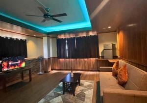 uma sala de estar com um sofá e uma ventoinha de tecto em Verde View Villas em Puerto Galera