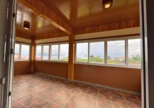 um quarto vazio com janelas numa casa em Verde View Villas em Puerto Galera