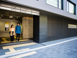 Ein Mann und eine Frau gehen in ein Gebäude in der Unterkunft Hyatt Place Kyoto in Kyoto