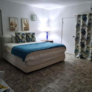 um quarto com uma cama grande e um cobertor azul em Palm Beach Retreat em Palm-Eagle Beach