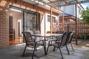 a patio with a table and chairs on a patio at Cheerful 6br4ba Clayton Courtyardwi-figarage in Clayton North