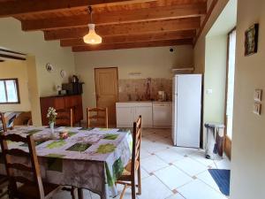 a kitchen and dining room with a table and a refrigerator at Maison spacieuse et confortable avec terrasse et jardin, idéale pour famille ou entreprise - FR-1-585-29 in Méligny-le-Grand +11 photos