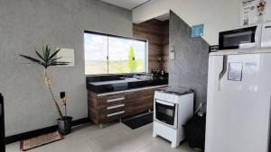 a kitchen with a sink and a window and a refrigerator at Casa (2) in Diamantina