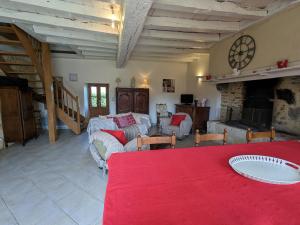 a living room with couches and a red table at Charmante maison berrichonne restaurée avec jardin, proche de la Vallée de la Creuse et du Lac d'Éguzon - FR-1-591-445 in Maillet