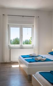 a bedroom with two beds and a window at Family-friendly apartments with swimming pool Rtina - Stosici, Zadar - 21450 in Rtina
