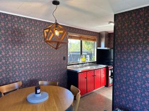 uma cozinha com uma mesa de madeira num quarto em Streamside Family Friendly Oasis with Spa em Rotorua