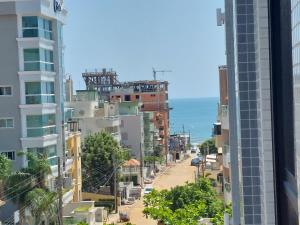 een stadsstraat met gebouwen en de oceaan op de achtergrond bij Ótimo Apto, Jacuzzi aquecida e piscina, pertinho da praia in Bombinhas