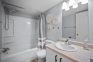 a white bathroom with a sink and a toilet at CHIC 2BR Near Keyano College Free Parking in Fort McMurray