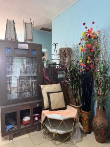 een winkel met een stoel en bloemen in een kamer bij Hutama Kaliurang Guest House in Soprayan