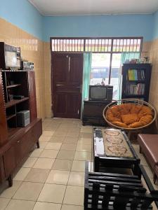 a living room with a bed and a tv at Hutama Kaliurang Guest House in Soprayan