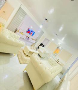 a living room with two white chairs and a table at White Emirates Hotel and Apartment in Lagos