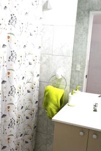 a bathroom with a shower curtain with a yellow towel at Grandioso departamento a cuadras de Parque O'higgins in Santiago
