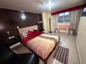 a bedroom with a large bed with red pillows at Hostal la perla del sur in Quito