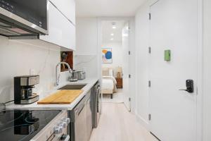 a white kitchen with a sink and a stove at 48-4FW Newly renovated W D Midtown in New York