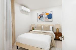 a white bedroom with a bed and a table at 48-4FW Newly renovated W D Midtown in New York