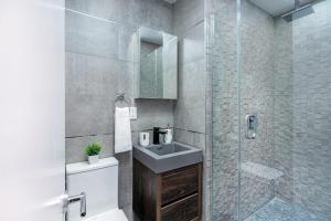 a bathroom with a sink and a glass shower at 48-4FW Newly renovated W D Midtown in New York