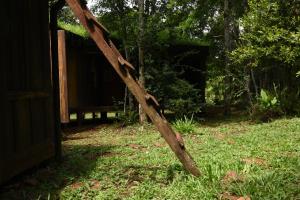 un poste de madera en la hierba junto a un cobertizo en Yerbas del Paraiso in 