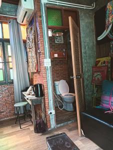 Un baño con inodoro en una pared de ladrillo. en Huen Chiang Man Hostel, en Chiang Mai