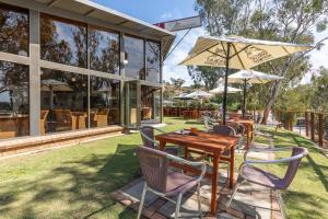a restaurant with tables and chairs and an umbrella at Mannum Motel in Mannum