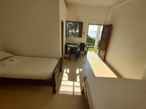 Habitación con 2 camas, escritorio y mesa. en La casa del mar, en San Bernardo del Viento