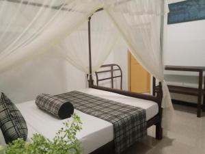 Sigiriya Rock Gate Resort في سيجيريا: غرفة نوم بسرير مع مظلة