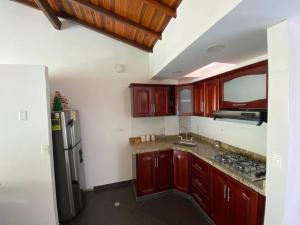cocina con armarios de madera y nevera de acero inoxidable en Hermoso Apartamento en San Gil en San Gil