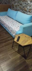 a blue couch with a remote control on a coffee table at Su camping in Dağpınar