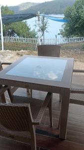 a table and chairs on a patio with a view of the water at Su camping in Dağpınar
