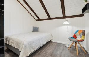 1 dormitorio con 1 cama y 1 silla en Cozy Home In Oksbl With Kitchen, en Oksbøl