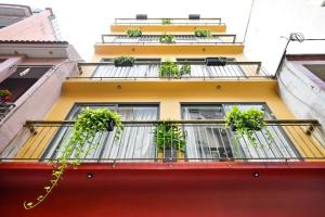 een geel gebouw met potplanten op een balkon bij Saigon Hotel & Apartment in Ho Chi Minh-stad