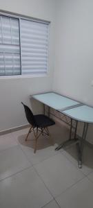 a glass table and a chair in a room at Big apartment close to Allianz Park in Sao Paulo