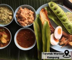talerz żywności z różnymi rodzajami żywności w obiekcie Homestay Eco Rengas Jaya w mieście Padang Rengas