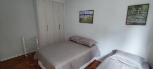 a bedroom with a bed and two pictures on the wall at Big apartment close to Allianz Park in Sao Paulo