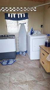 una lavanderia con due lavatrici e una lavatrice/asciugatrice di psalms a Cunupia Village