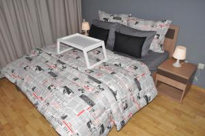 a bed with a comforter and a table on it at Val Fleuri Apartment with 2 Balconies, Casablanca in Casablanca