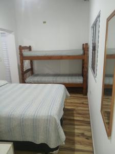 a bedroom with two beds and a mirror at Casa mirante Bela Vista in Guarujá