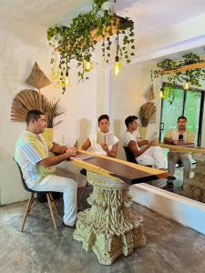 Eine Gruppe von Männern, die an einem Tisch sitzen. in der Unterkunft Hotel and hostel KAB in Cancún
