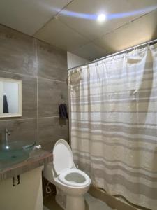 a bathroom with a toilet and a sink at Tumbes Zorritos Bocapan Casa con piscina 3 dormitorios in Bocapán