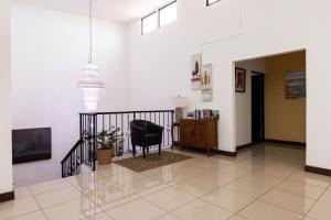 un couloir avec une chaise noire et un bureau dans l'établissement Viva Guest House, à San José