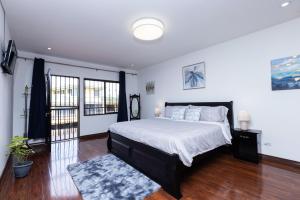 1 dormitorio con 1 cama grande con sábanas blancas en Viva Guest House, en San José