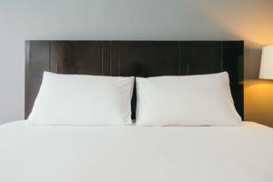 2 cuscini bianchi su un letto in una camera da letto di Hostal Kollarón a Chachapoyas