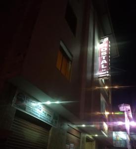 un'insegna al neon sul lato di un edificio di notte di Hostal Kollarón a Chachapoyas