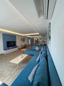 a large blue couch in a living room at درة العروس خمس غرف وصالة مع بالكونة على شاطئ البرادايس - عوائل in Durat  Alarous