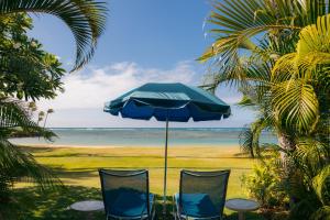 two chairs and an umbrella on the beach at The Kahala Hotel and Resort in Honolulu