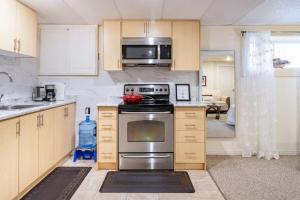 a kitchen with a stainless steel stove and microwave at KD Bachelor Suite - Lower Level in Barrie