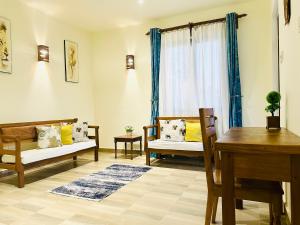 a living room with chairs and a table and a window at Almond Ridge - Villa Mfalme in Kinondo