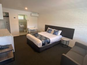 a bedroom with a bed and a brick wall at Southern Ocean Motor Inn in Port Campbell