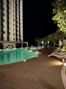 a swimming pool in front of a building at night at Seaside Pool View Studio Apartment at Kota Kinabalu City Centre in Kota Kinabalu