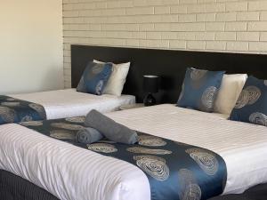 two beds sitting next to each other in a room at Southern Ocean Motor Inn in Port Campbell