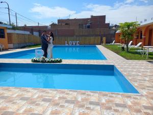 a bride and groom standing in front of a swimming pool at BUENDIA HOTEL in Pueblo Viejo